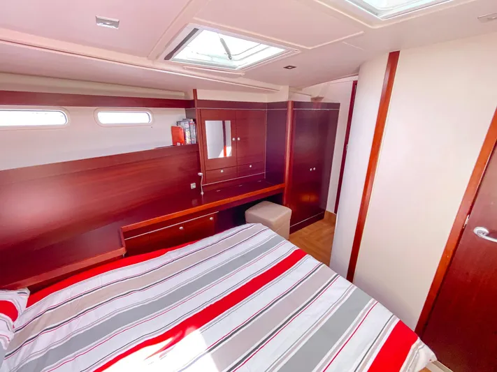  Yacht Photos Pics Luxurious 2010 Hanse 545 yacht cabin with striped bedding and elegant wood finishes.
