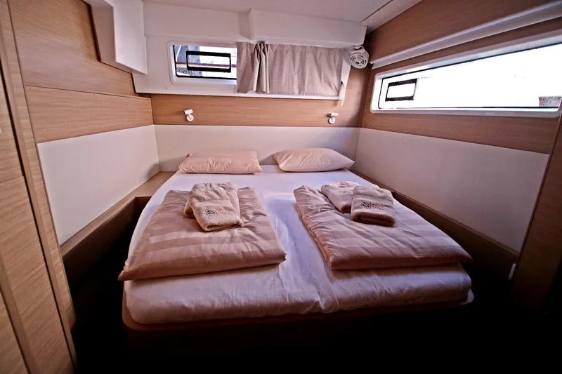  Yacht Photos Pics Luxurious cabin interior of 2025 Lagoon 43 yacht with cozy bedding and modern design.