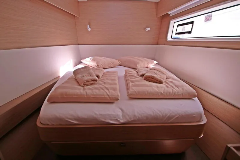  Yacht Photos Pics Luxurious cabin interior of 2025 Lagoon 43 yacht with cozy bedding and natural light.