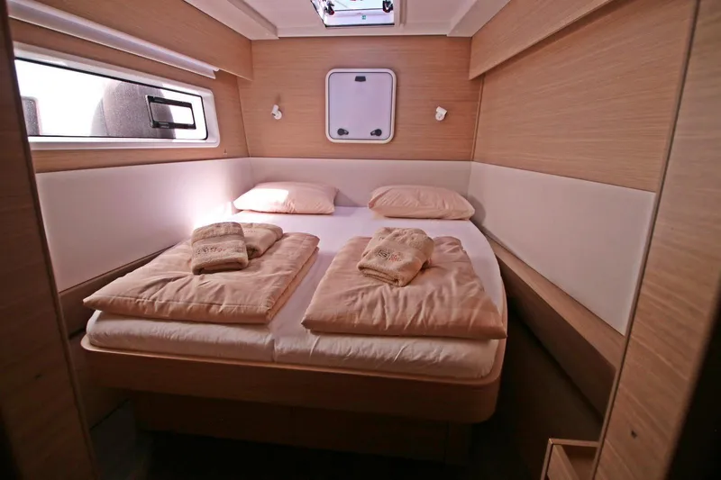  Yacht Photos Pics Luxurious cabin interior of 2025 Lagoon 43 yacht with cozy bedding and natural light.