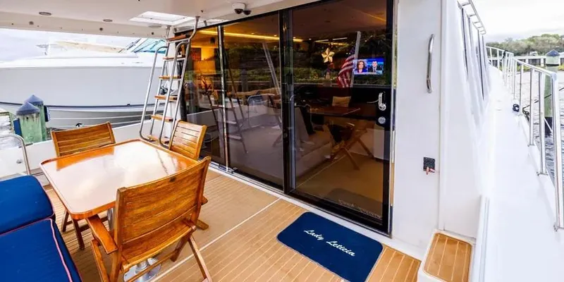  Yacht Photos Pics Outdoor dining area on 2000 Pacific Mariner 65 Motoryacht with wooden table and chairs.