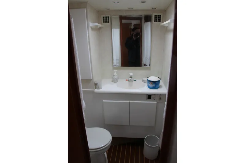 Galatea Yacht Photos Pics Small bathroom with mirror, sink, and toilet in a 2000 Post 50 model.