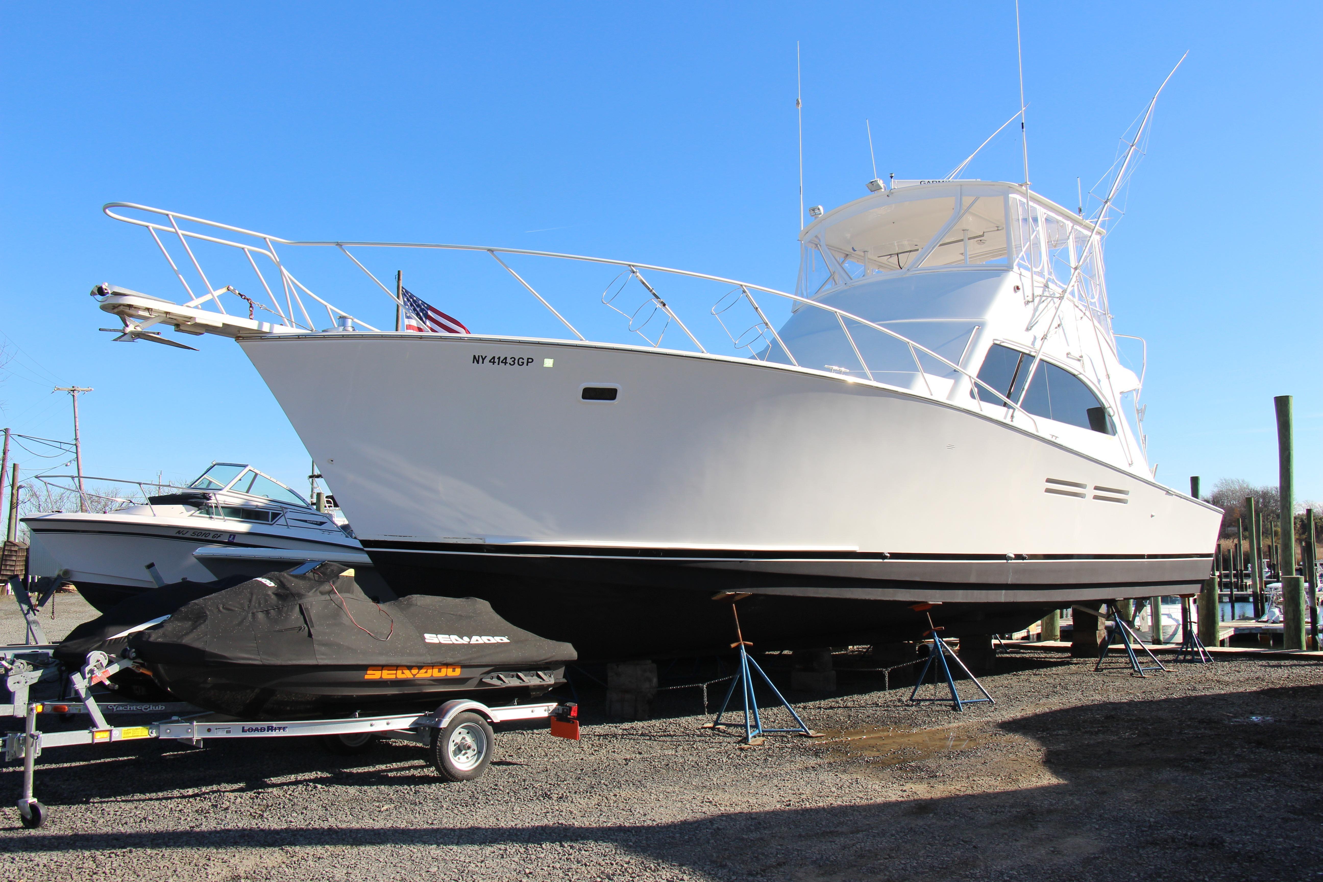 White Post 50 yacht from 2000 on dry dock, with jet ski nearby.