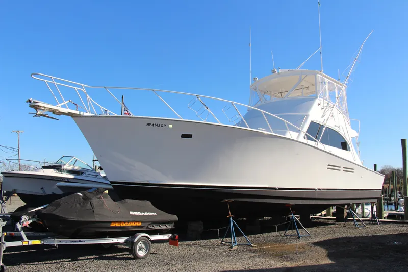 Galatea Yacht Photos Pics White 2000 Post 50 yacht on dry dock with a covered jet ski nearby.