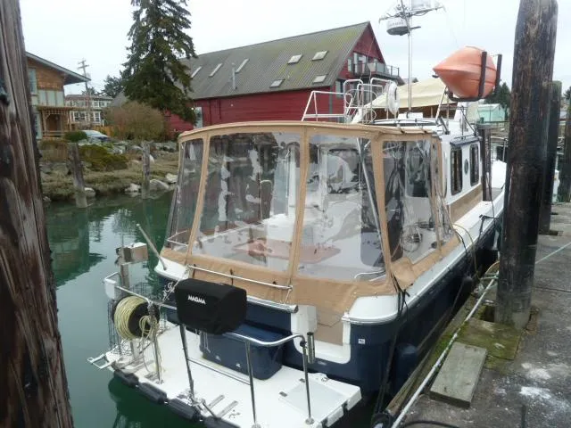 Island Wanderer Yacht Photos Pics 2013 Ranger Tugs R-31 docked, featuring a covered deck and scenic waterfront setting.