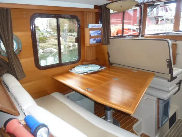 Island Wanderer Yacht Photos Pics Interior of 2013 Ranger Tugs R-31 with wooden table and seating area.