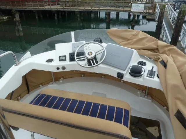 Island Wanderer Yacht Photos Pics 2013 Ranger Tugs R-31 helm with steering wheel, navigation equipment, and seating.