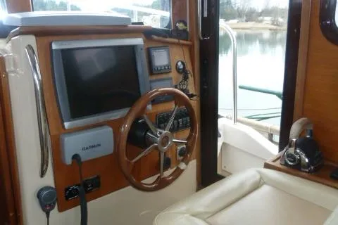 Island Wanderer Yacht Photos Pics 2013 Ranger Tugs R-31 helm with steering wheel, navigation equipment, and comfortable seating.