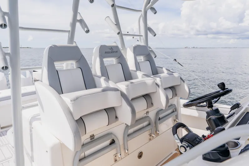  Yacht Photos Pics 2018 Regulator 41 boat helm with three white cushioned seats and steering wheel.