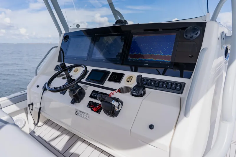  Yacht Photos Pics Control panel of a 2018 Regulator 41 boat with navigation screens and steering wheel.