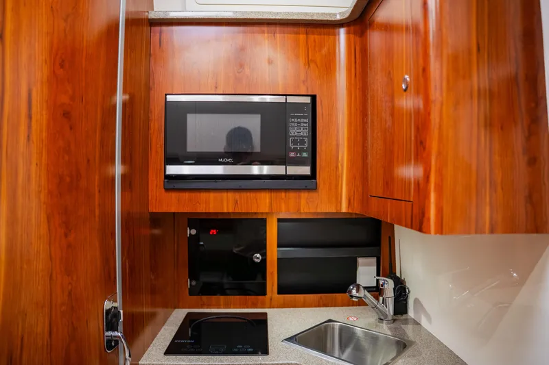  Yacht Photos Pics Luxurious 2018 Regulator 41 yacht kitchen with microwave, sink, and wooden cabinetry.