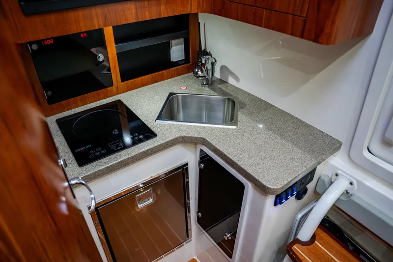  Yacht Photos Pics 2018 Regulator 41 boat kitchen with sink, stove, and storage cabinets.