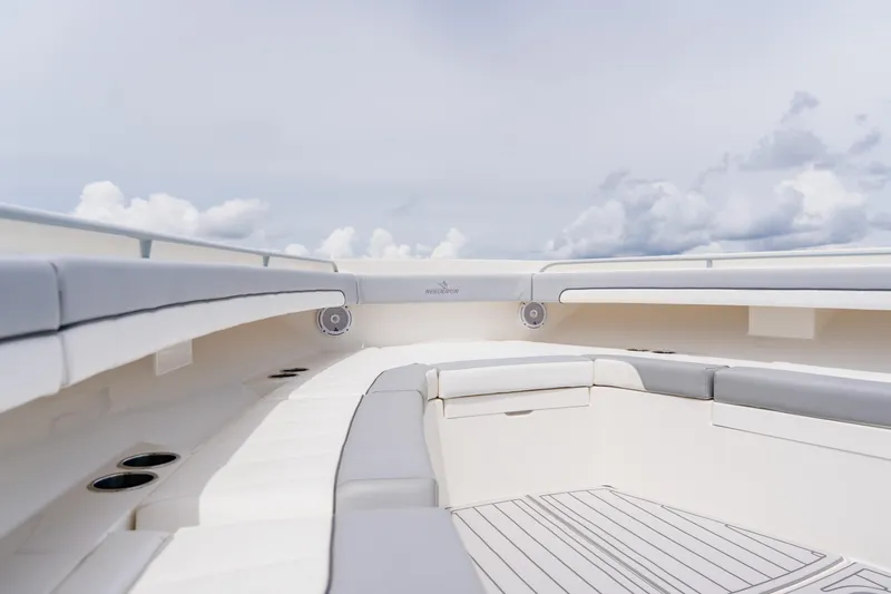  Yacht Photos Pics 2018 Regulator 41 boat interior with cushioned seating and cup holders under a cloudy sky.