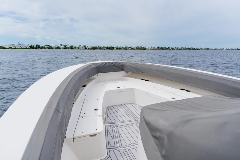  Yacht Photos Pics 2018 Regulator 41 boat interior with cushioned seating, on calm water, under a cloudy sky.