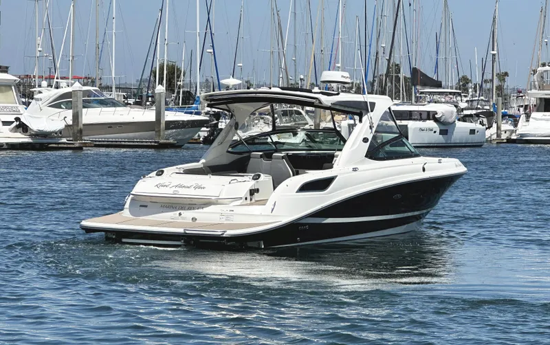 Knot About You Yacht Photos Pics 2017 Sea Ray SLX 350 boat docked in a marina with sailboats in the background.