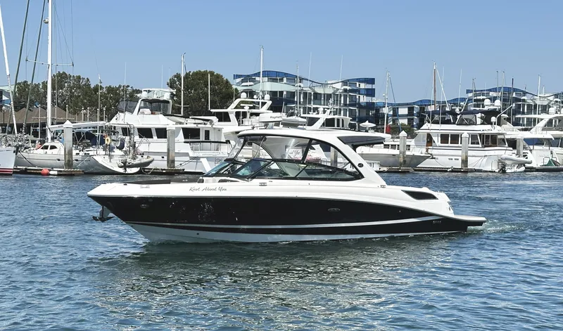 Knot About You Yacht Photos Pics 2017 Sea Ray SLX 350 boat cruising in a marina with yachts in the background.