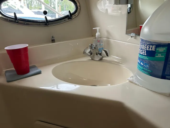 Matilda Bay Yacht Photos Pics 1997 Tiara Yachts 3500 Express bathroom sink with red cup and antifreeze bottle.
