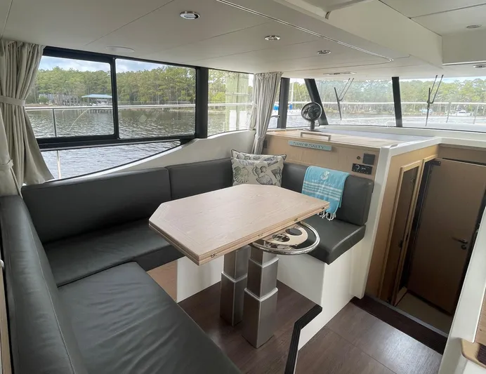 Sweetest Southern Comfort Yacht Photos Pics Luxurious interior of 2022 Beneteau ST48 yacht with elegant seating and scenic window views.