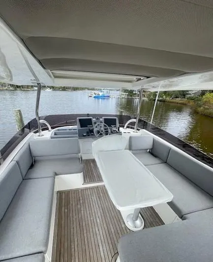 Sweetest Southern Comfort Yacht Photos Pics 2022 Beneteau ST48 yacht interior with seating and table, overlooking serene waterway.