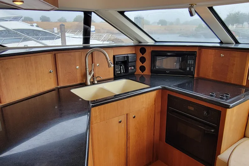 Escape II Sea Yacht Photos Pics 2003 Silverton 453 Motor Yacht kitchen with wood cabinets, sink, microwave, and oven.