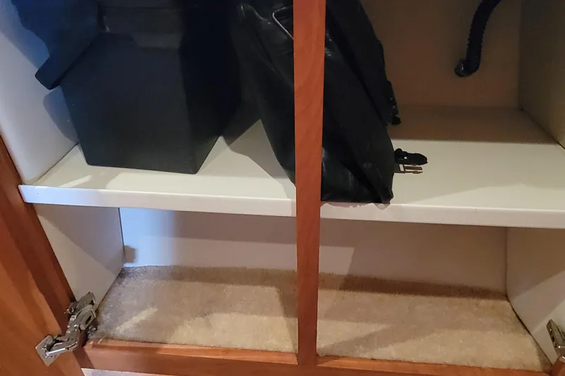 Escape II Sea Yacht Photos Pics Open cabinet in 2003 Silverton 453 Motor Yacht, showing storage space and items.