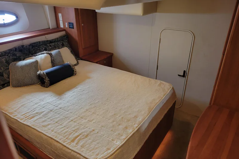 Escape II Sea Yacht Photos Pics Luxurious bedroom in 2003 Silverton 453 Motor Yacht with elegant bedding and wood accents.