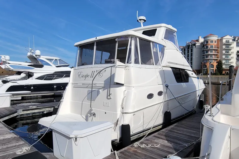 Escape II Sea Yacht Photos Pics 2003 Silverton 453 Motor Yacht docked at marina with modern buildings in background.