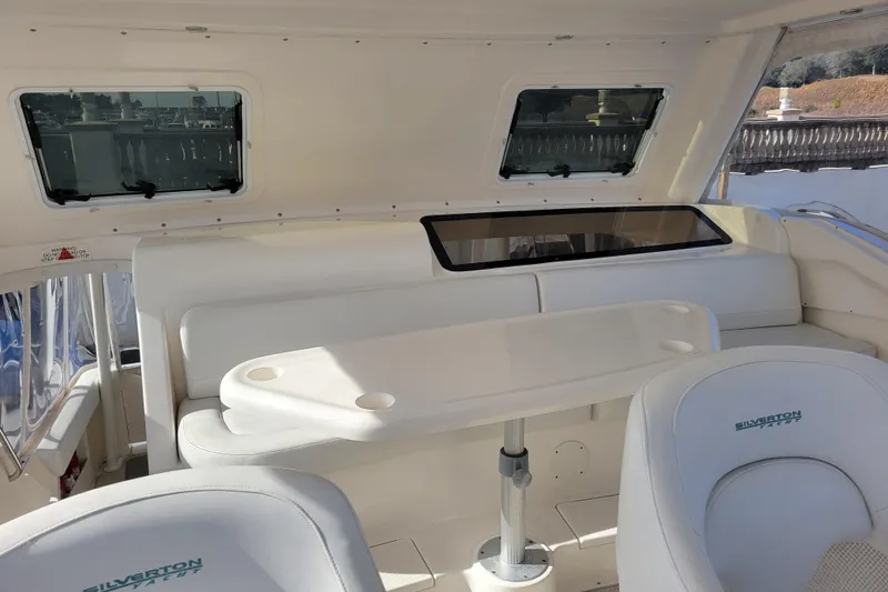 Escape II Sea Yacht Photos Pics 2003 Silverton 453 Motor Yacht interior with seating and table, featuring windows and white upholstery.