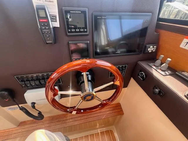 Windless Yacht Photos Pics 2016 Ranger Tugs R-29 S Tug helm with wooden steering wheel and navigation controls.
