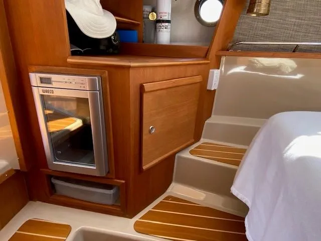 Windless Yacht Photos Pics Interior of 2016 Ranger Tugs R-29 S Tug with wood cabinetry and compact fridge.