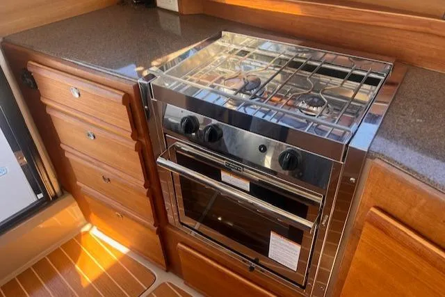 Windless Yacht Photos Pics 2016 Ranger Tugs R-29 S Tug kitchen with stove and wooden cabinetry.