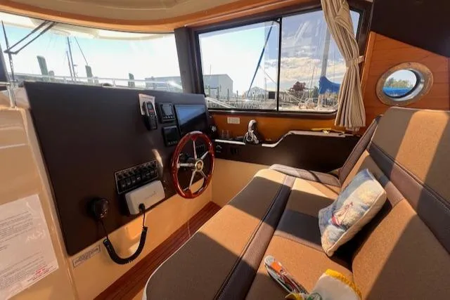 Windless Yacht Photos Pics Interior of 2016 Ranger Tugs R-29 S Tug with steering wheel and seating area.