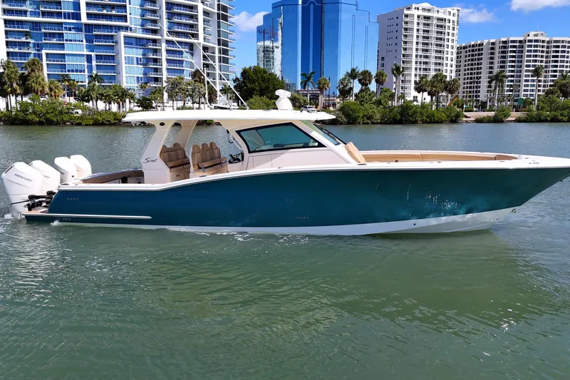 Perfect Season Yacht Photos Pics 2024 Scout 425 LXF boat cruising on water near modern cityscape.