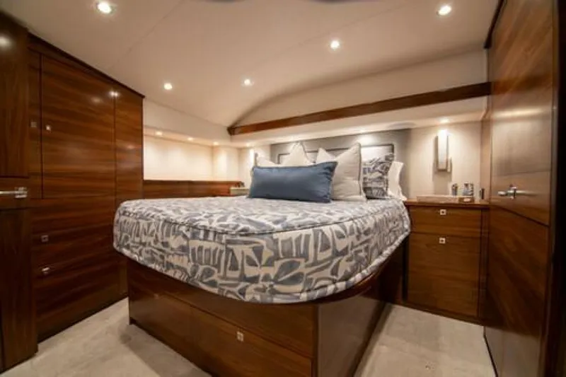 Caballo Grande Yacht Photos Pics Luxurious bedroom interior of 2024 Viking 68 Enclosed Bridge yacht with elegant wood finishes.