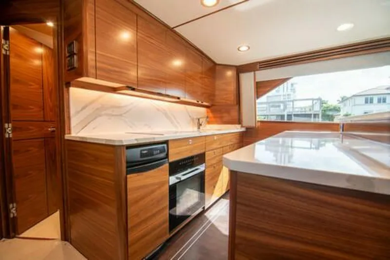 Caballo Grande Yacht Photos Pics Luxurious kitchen interior of 2024 Viking 68 Enclosed Bridge yacht with modern wood cabinetry.