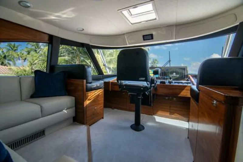 Caballo Grande Yacht Photos Pics Luxurious interior of 2024 Viking 68 Enclosed Bridge yacht with plush seating and modern helm.