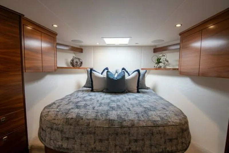 Caballo Grande Yacht Photos Pics Luxurious bedroom interior of 2024 Viking 68 Enclosed Bridge yacht with elegant wood cabinetry.