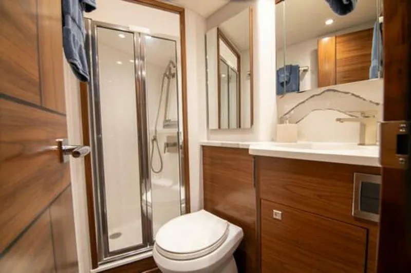 Caballo Grande Yacht Photos Pics Luxurious bathroom in 2024 Viking 68 Enclosed Bridge yacht with modern fixtures and wood accents.