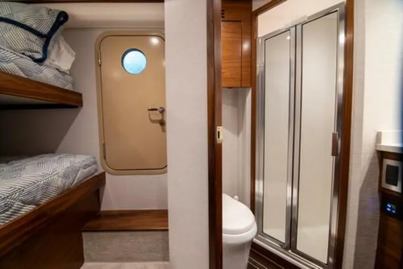 Caballo Grande Yacht Photos Pics 2024 Viking 68 Enclosed Bridge interior with bunk beds and bathroom.