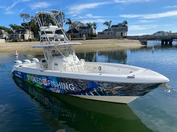 Stoked On Fishing Yacht Photos Pics 2008 Everglades 355 Center Console boat with vibrant fishing graphics on calm water.