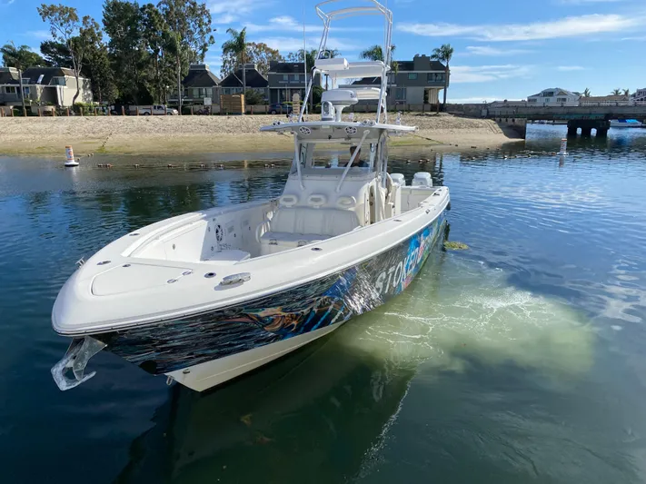 Stoked On Fishing Yacht Photos Pics 2008 Everglades 355 Center Console boat on calm water near a sandy shore.