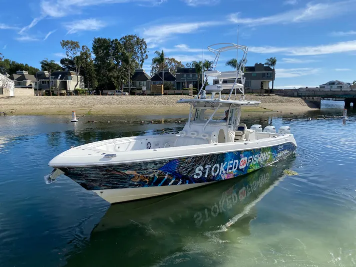 Stoked On Fishing Yacht Photos Pics 2008 Everglades 355 Center Console boat on calm water near a sandy shore.
