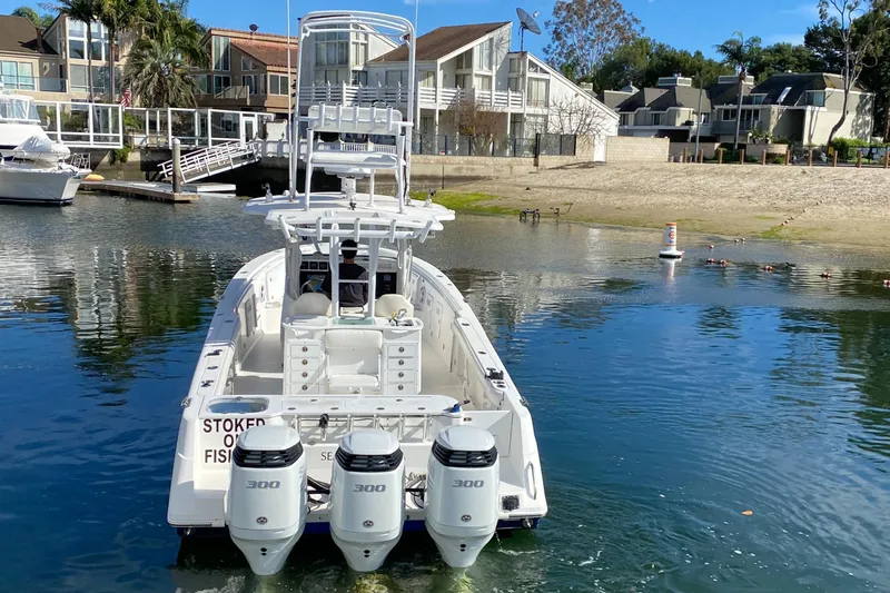 Stoked On Fishing Yacht Photos Pics 2008 Everglades 355 Center Console boat with triple 300 horsepower engines docked near waterfront homes.