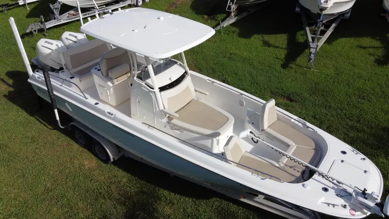  Yacht Photos Pics 2020 Boston Whaler 270 Dauntless boat on grass, featuring sleek design and spacious seating.