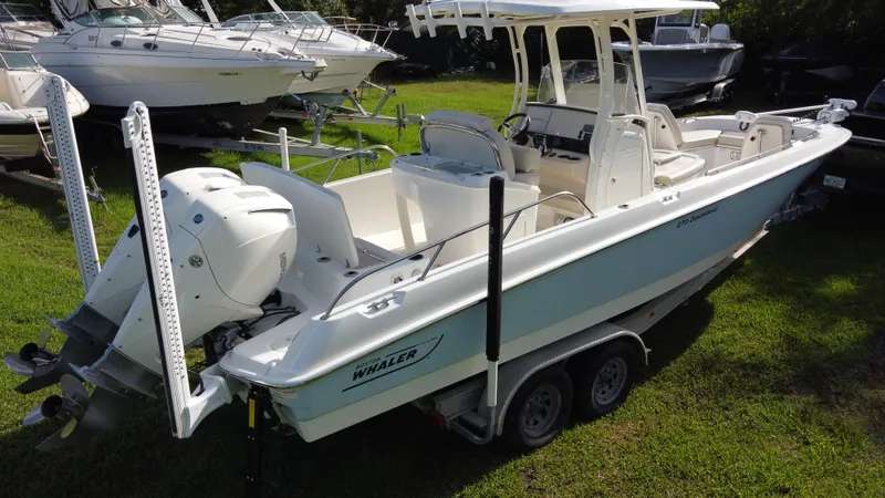  Yacht Photos Pics 2020 Boston Whaler 270 Dauntless boat on trailer, parked on grass.
