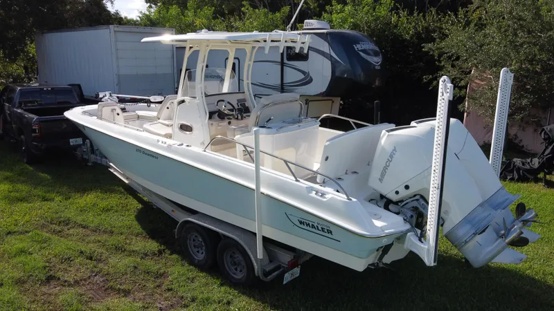  Yacht Photos Pics 2020 Boston Whaler 270 Dauntless boat on trailer, parked on grass.