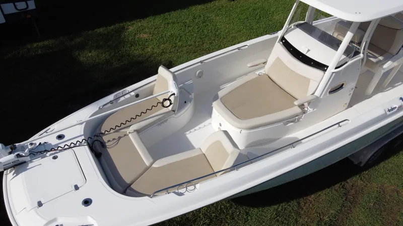  Yacht Photos Pics 2020 Boston Whaler 270 Dauntless boat with spacious seating and sleek design on grass.