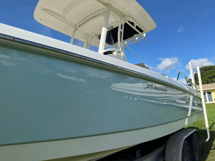  Yacht Photos Pics 2020 Boston Whaler 270 Dauntless boat on trailer under clear blue sky.