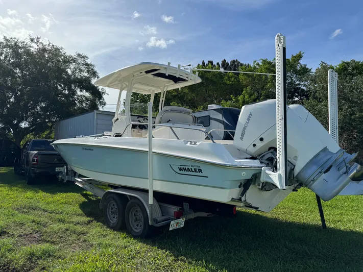 Yacht Photos Pics 2020 Boston Whaler 270 Dauntless boat on trailer, parked on grass.