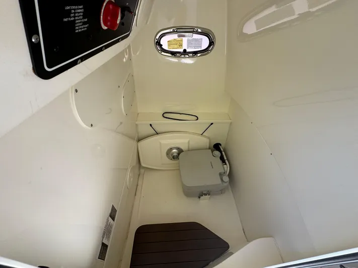  Yacht Photos Pics 2020 Boston Whaler 270 Dauntless interior cabin with compact toilet and porthole.